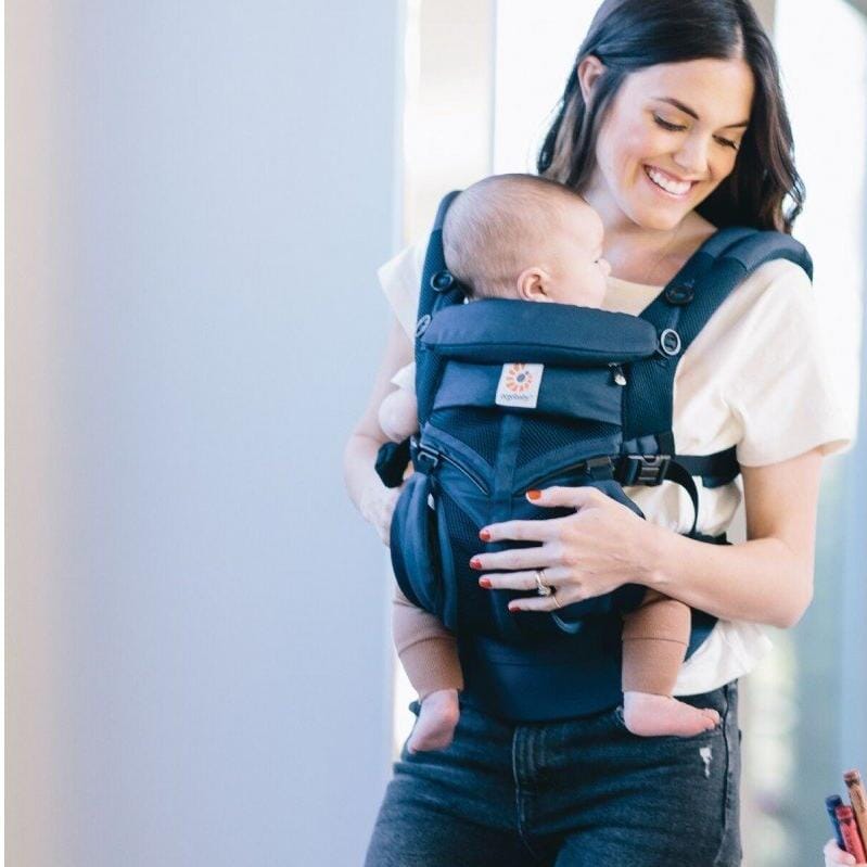 maman prend bebe dans porte bebe bleu face a elle
