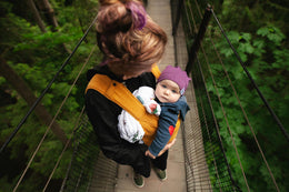 maman prend bebe dan porte bebe orange