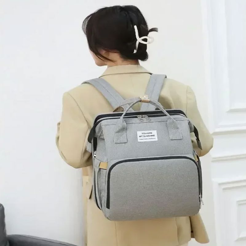 sac a langer gris sur os de maman
